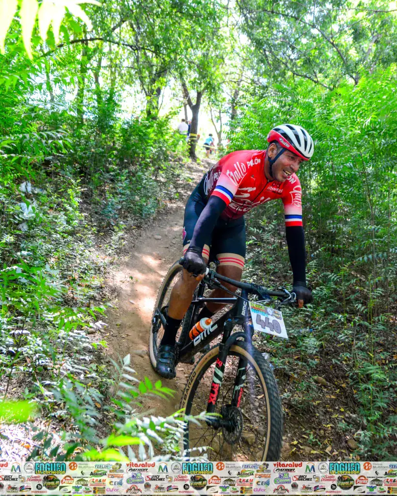 Ciclista en sendero de montaña en un entorno natural y verde.