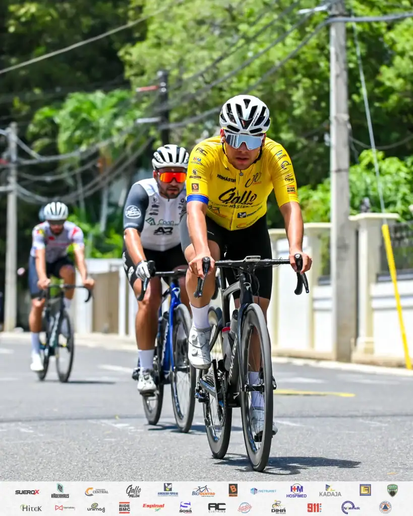 Ciclistas profesionales en una carrera en carretera, usando cascos y ropa deportiva, pedalear con es.
