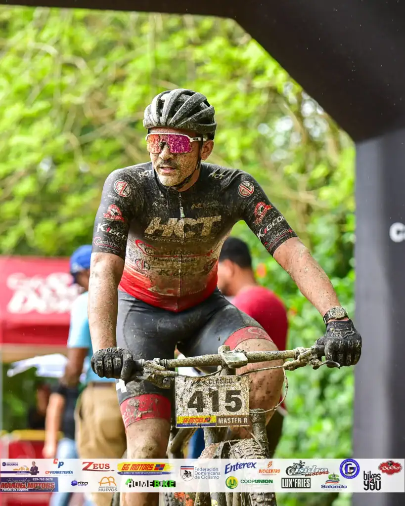 Denny Lopez en carrera de ciclismo en naturaleza, usando casco y gafas deportivas.