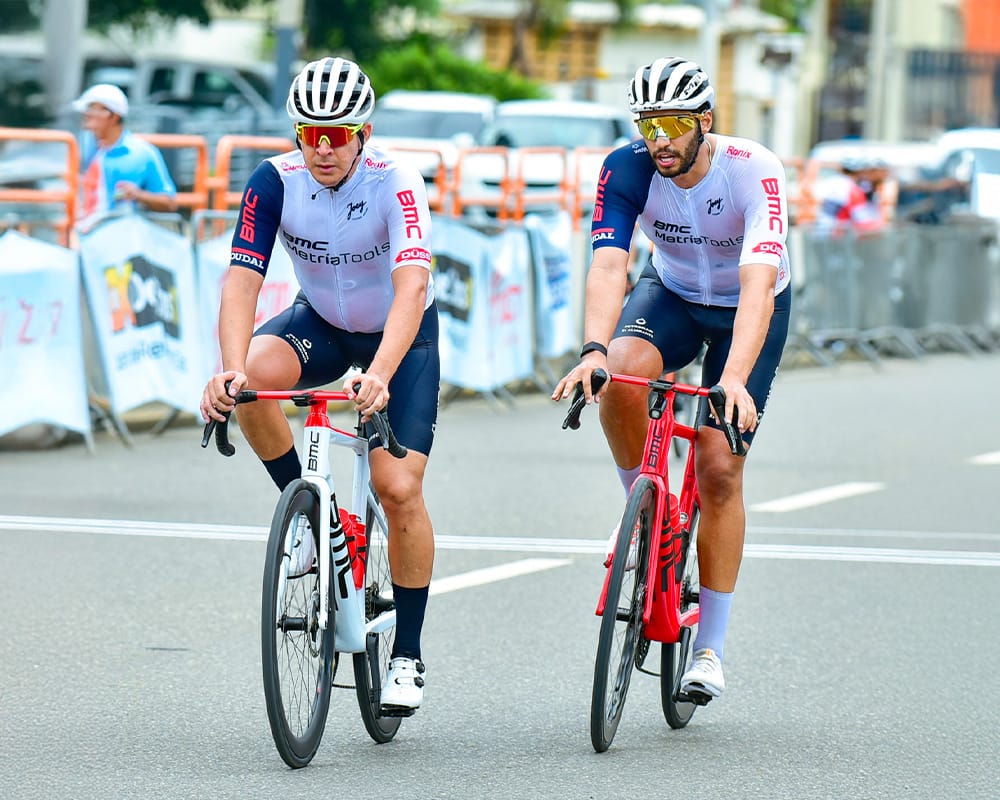 Ciclistas profesionales en una carrera de ciclismo en la ciudad, usando cascos y ropa deportiva, ped.