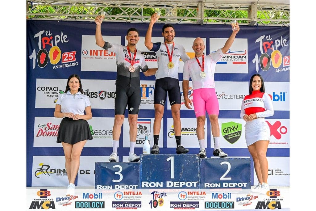 Atletas en el podio celebrando su victoria en una competencia de ciclismo.